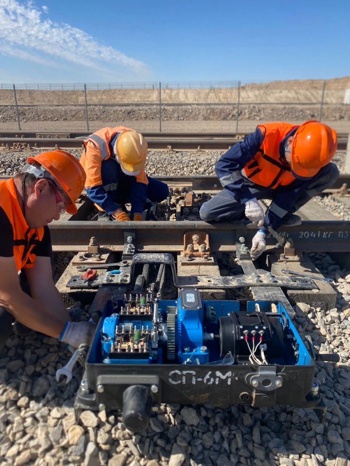Workers performing maintenance on railway tracks in Жанатас, Kazakhstan.